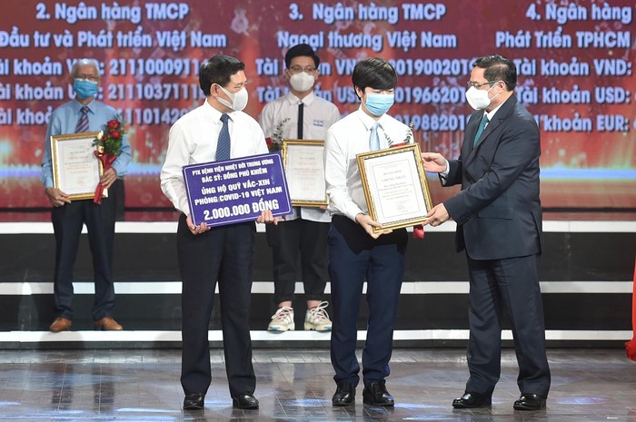 Thủ tướng Chính phủ Phạm Minh Chính trao chứng nhận, hoa, cảm ơn Bác sĩ Đồng Phú Khiêm, Phó trưởng khoa điều trị tích cực - Bệnh viện Bệnh Nhiệt đới Trung ương.