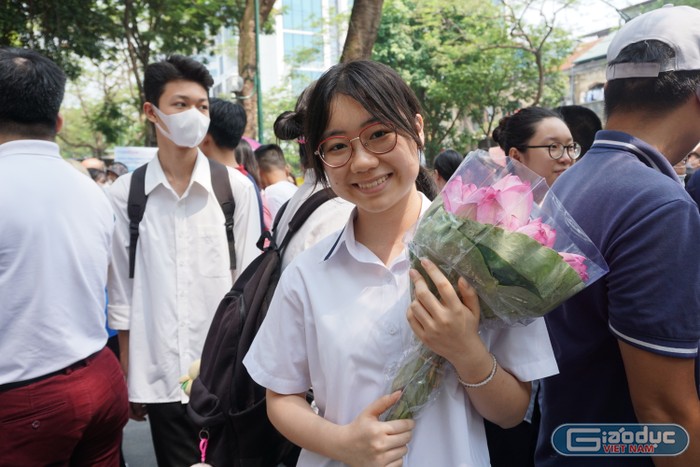 Học sinh Hiền Anh hạnh phúc vì hoàn thành bài thi tốt và được bố mẹ tặng hoa sen mình yêu thích. Ảnh: Phạm Minh
