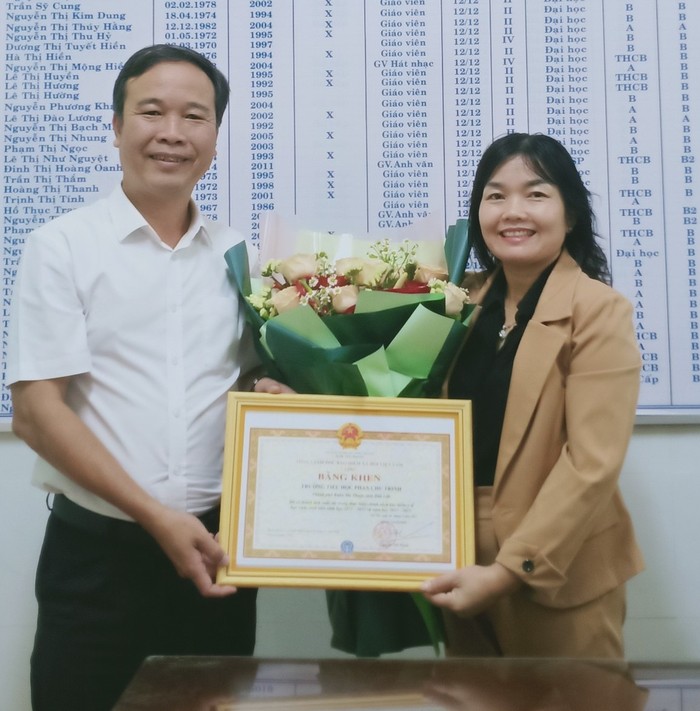 Cô giáo Đặng Thị Hải Yến đại diện nhà trường nhận bằng khen của Tổng Giám đốc Bảo hiểm xã hội Việt Nam.