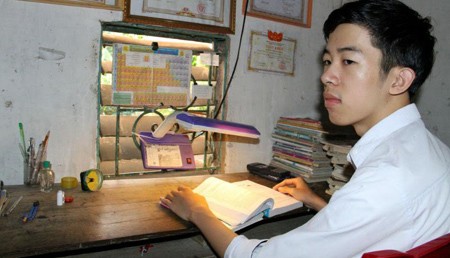 Nguyễn Đức Ngà bên góc học tập đơn sơ ở nhà. Ảnh Liêm Thanh