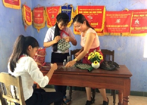 Hình ảnh 2 em Thư và Thuận đang tận dụng những vật phế thải để làm ra các món đồ thủ công mỹ nghệ. (Ảnh: tác giả cung cấp).