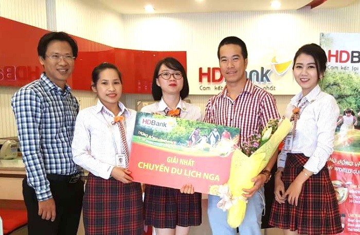 Khách hàng Bạch Minh Khoa (thứ hai từ phải sang) giao dịch tại HDBank Lê Quang Định (TP HCM) nhận giải nhất – chuyến du lịch xem WorldCup 2018 tại Nga trị giá 50 triệu đồng.