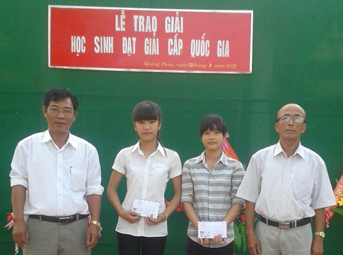 Thầy Nguyễn Thành Luật (bên trái) cùng Ban đại diện cha mẹ học sinh trao phần thưởng cho các em học sinh giỏi của trường (Ảnh: tác giả cung cấp).