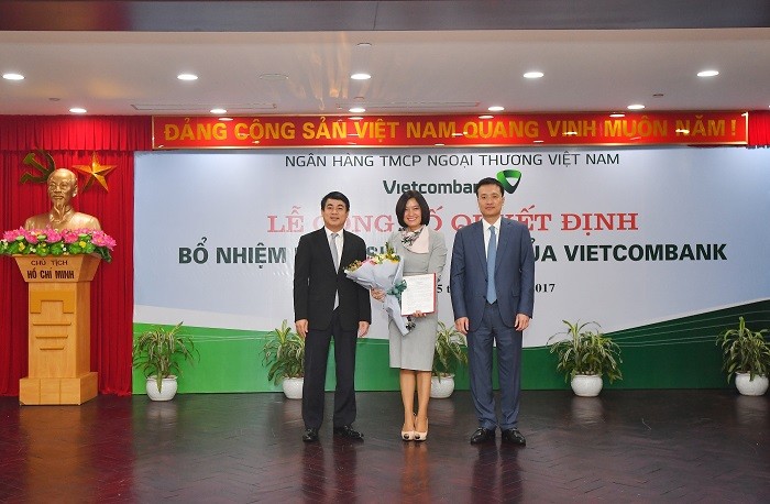 Chủ tịch Hội đồng quản trị Vietcombank Nghiêm Xuân Thành (bên trái) và Tổng Giám đốc Vietcombank Phạm Quang Dũng (bên phải) trao Quyết định và tặng hoa chúc mừng Bà Phùng Nguyễn Hải Yến – tân Phó Tổng Giám đốc Vietcombank.