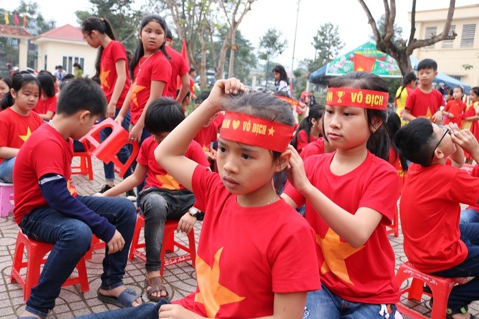 Một số em khác ngồi chỉnh lại trang phục để chuẩn bị tiếp sức cho đội tuyển U23 Việt Nam.