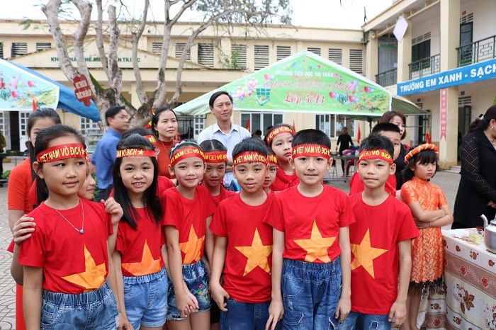 Các em học sinh không ai bảo ai đều đồng phục áo đỏ, thắt băng đỏ với hàng chữ vàng nổi bật: “Tôi yêu Việt Nam. Việt Nam vô địch”.