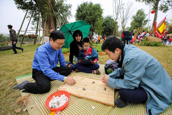 Cả gia đình cùng nhau thử sức ở các trò chơi dân gian. (Ảnh: Minh Sơn/Vietnam+).