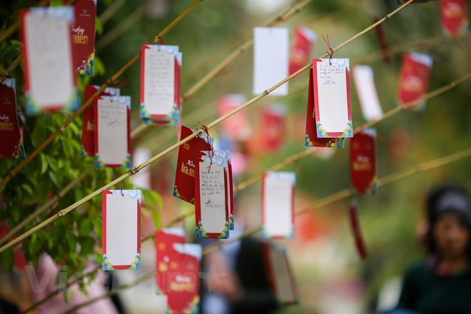 Đến với lễ hội, du khách còn được viết những mong muốn của mình trong năm mới và treo lên cây nguyện ước. (Ảnh: Minh Sơn/Vietnam+)