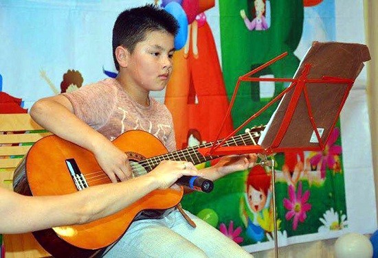 Cháu Việt Đức, 10 tuổi, độc tấu đàn Ghita (Ảnh: tác giả cung cấp).