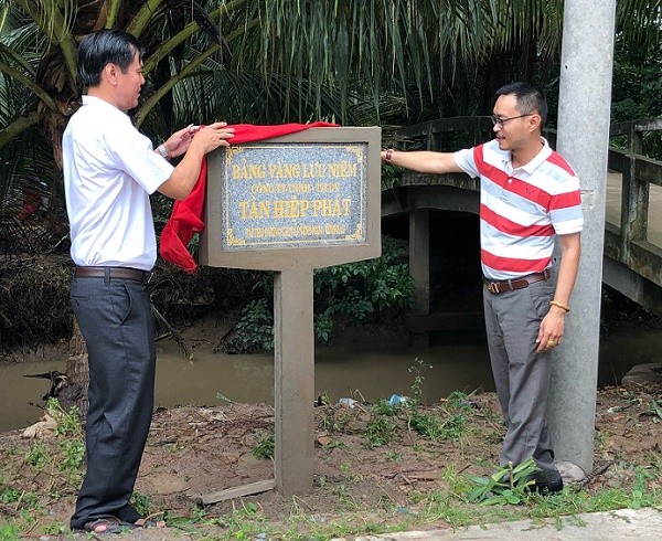 Ông Lê Nguyễn Đức Khôi cùng ông Lê Đình Lâm, Chủ tịch Ủy ban nhân dân xã Đại Điền, huyện Thạnh Phú mở bảng tri ân nhà tài trợ do Ủy ban nhân dân xã làm tặng.