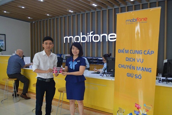 Đại diện cửa hàng MobiFone Nguyễn Chí Thanh trao cặp vé AFF cho khách hàng may mắn.