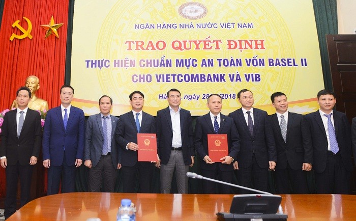 Thống đốc Ngân hàng nhà nước Việt Nam Lê Minh Hưng (đứng giữa) cùng Phó Thống đốc Ngân hàng nhà nước Đoàn Thái Sơn (thứ 3 từ trái sang) chúc mừng và chụp ảnh lưu niệm cùng Ban Lãnh đạo Vietcombank và các đại biểu.