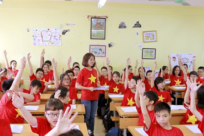 Các em học sinh cùng nhau giơ cao cánh tay, đồng lòng, quyết tâm cổ vũ hết mình cho đội tuyển bóng đá Việt Nam.