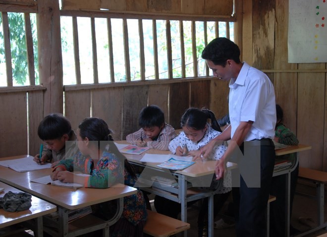 Thầy giáo vùng cao tận tình dạy chữ cho các em học sinh (Ảnh minh họa: TTXVN).
