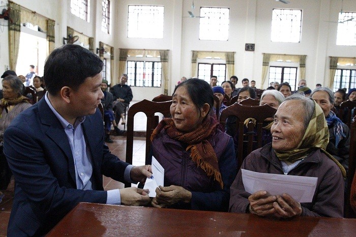 Nhà báo Nguyễn Tiến Bình trao quà và thăm hỏi bà Vi Thị Lợi 77 tuổi ở xã Đông Thành.