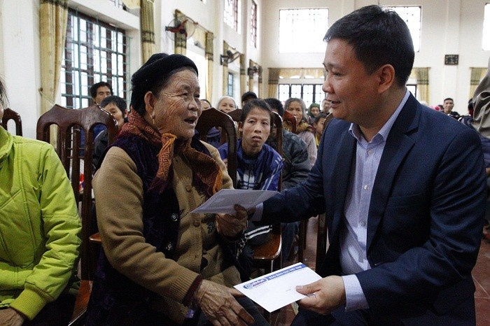 Tổng biên tập Báo Điện tử Giáo dục Việt Nam trao quà cho bà Vi Thị Kinh 84 tuổi ở xã Đông Thành.