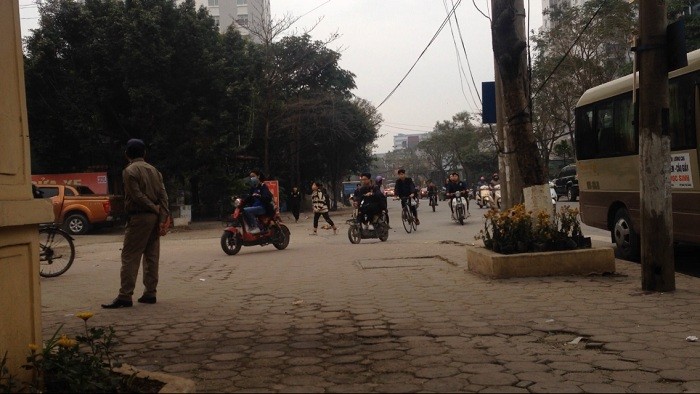 Trước cổng Trường trung học phổ thông Nguyễn Bỉnh Khiêm (quận Cầu Giấy, Hà Nội), nhiều học sinh đi xe máy điện không đội mũ bảo hiểm. Ảnh: Công Tiến