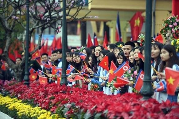 Hàng trăm học sinh trung học phổ thông trong thành phần đón đoàn, tay cầm hoa và cờ Việt Nam và Triều Tiên đã vẫy chào Chủ tịch Kim Jong Un.