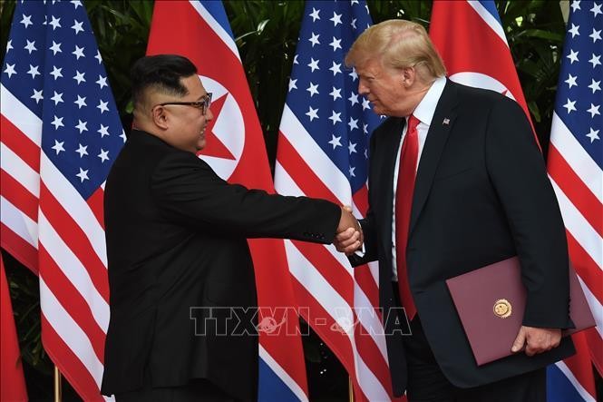 Tổng thống Mỹ Donald Trump (phải) và Nhà lãnh đạo Triều Tiên Kim Jong-un trong cuộc gặp thượng đỉnh lịch sử ở Singapore ngày 12/6/2018. Ảnh: AFP/TTXVN