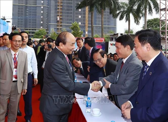 Thủ tướng Nguyễn Xuân Phúc bắt tay Tổng giám đốc TTXVN Nguyễn Đức Lợi và các đại biểu dự khai mạc. Ảnh: Thống Nhất/TTXVN