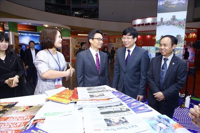 Phó Thủ tướng Vũ Đức Đam và các đại biểu tham quan gian trưng bày các ấn phẩm của Thông tấn xã Việt Nam tại Hội báo toàn quốc 2019.