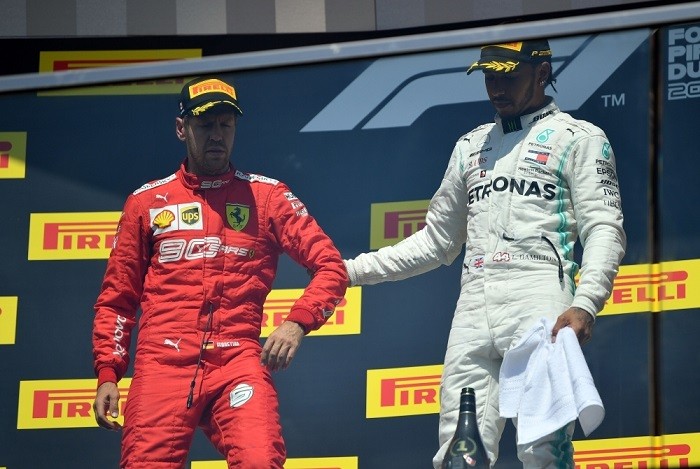 Vettel (áo đỏ) tỏ ra khó chịu khi bước lên bục nhận giải.