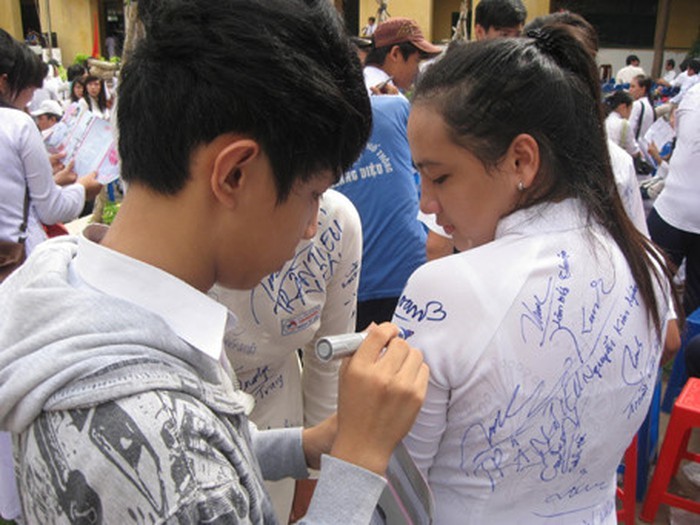 Các bạn học sinh lưu lại dòng lưu bút trên những chiếc áo dài (Ảnh minh họa: kienthuc.net.vn).