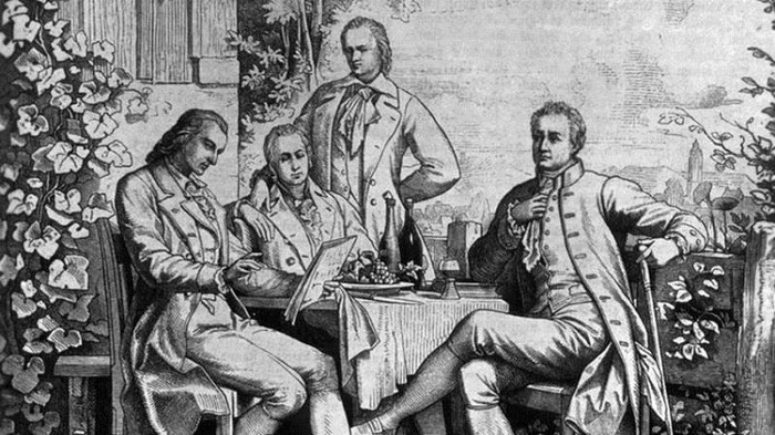 Alexander von Humboldt (đứng), Goethe, Schiller và anh trai Wilhelm von Humboldt ngồi từ trái sang phải.