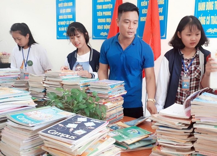 Thầy Nghị (áo xanh) cùng các em học sinh chuẩn bị cho Chương trình quyên góp sách giáo khoa cũ để tặng các em học sinh ở Lai Châu. Ảnh: NVCC
