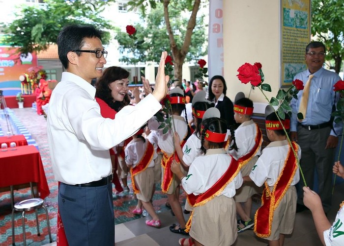 Phó Thủ tướng Vũ Đức Đam cùng đón học sinh lớp 1 của Trương tiểu học Lê Văn Tám. Ảnh: VGP/Đình Nam