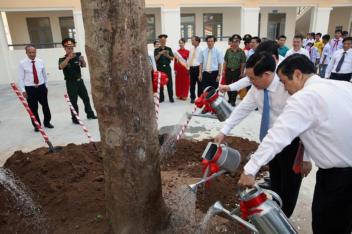 Phó Thủ tướng Vương Đình Huệ và lãnh đạo tỉnh Thái Bình trồng cây phượng vĩ tạo bóng mát trên sân trường mới xây dựng. Ảnh: VGP/Thành Chung