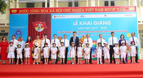 Phó Thủ tướng tặng mũ bảo hiểm cho các cháu học sinh lớp 1. Ảnh VGP/Lê Sơn.