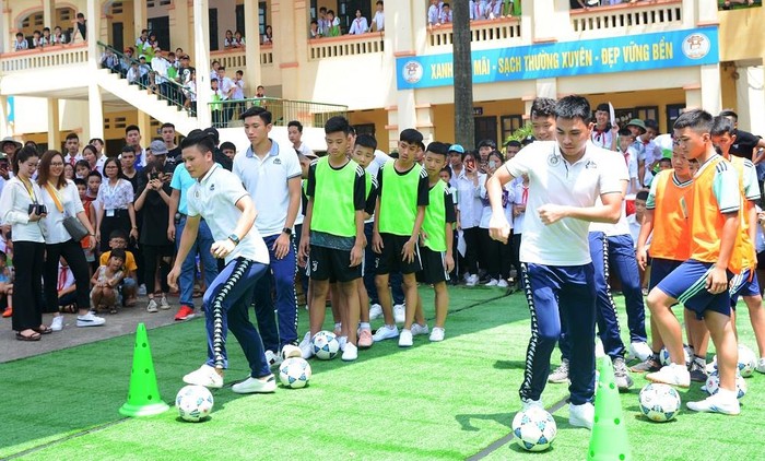 Các tuyển thủ quốc gia trong màu áo Câu lạc bộ Hà Nội cùng giao lưu trò chơi dẫn bóng cùng với các bạn học sinh. Ảnh: Công Tiến.