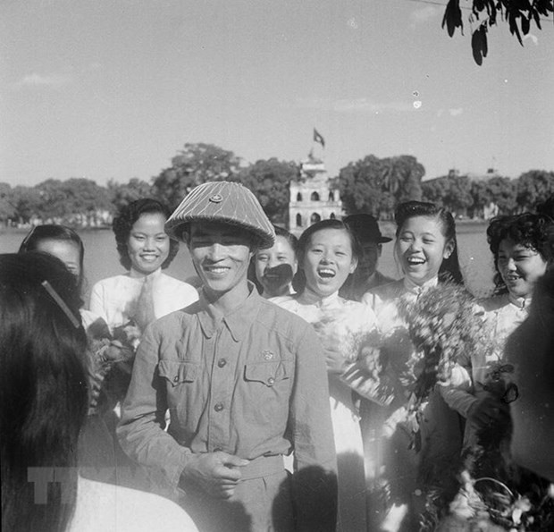 Nữ sinh Hà Nội đón chào Thiếu tướng Vương Thừa Vũ, Chủ tịch Ủy ban Quân chính Hà Nội, người dẫn đầu đoàn quân chiến thắng về giải phóng Thủ đô. (Ảnh: Tư liệu TTXVN)