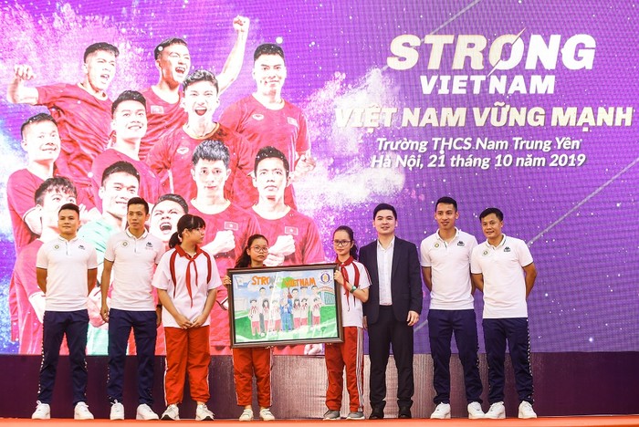 Các em học sinh Trường trung học cơ sở Nam Trung Yên tặng tranh cho các cầu thủ của Câu lạc bộ Bóng đá Hà Nội FC. Ảnh: Công Tiến
