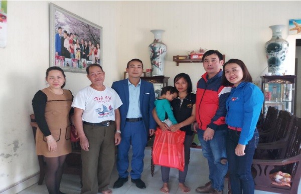 Cô giáo Đinh Vân Hồng (áo xanh thứ nhất bên phải) trao quà cho gia đình đoàn viên có hoàn cảnh khó khăn trong nhà trường (Xuân 2019). Ảnh: HV.