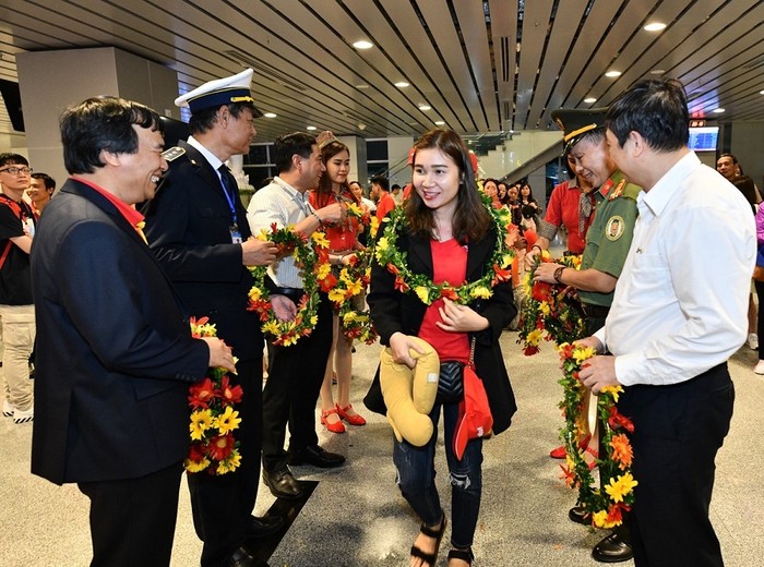 Các hành khách đầu tiên nhận những bó hoa tươi thắm và sẵn sàng cho chuyến bay đến Tokyo.