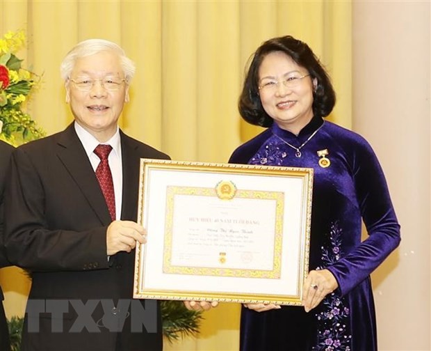 Tổng Bí thư, Chủ tịch nước Nguyễn Phú Trọng trao Huy hiệu 40 năm tuổi Đảng tặng đồng chí Đặng Thị Ngọc Thịnh. Ảnh: TTXVN