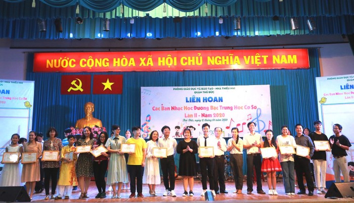Thầy Dương Hoàng Tuấn (Trưởng phòng Giáo dục và Đào tạo) và chị Nguyễn Thị Minh Hồng (Bí thư Quận đoàn) cùng trao giải A cho 9 nhóm nhạc. Ảnh: Cẩm Vân.