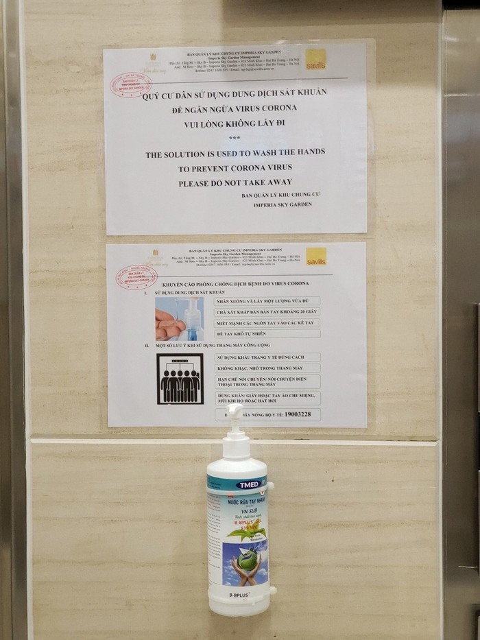 Khuyến cáo phòng chống dịch và dung dịch sát khuẩn được trang bị tại khu vực thang máy chung cư.