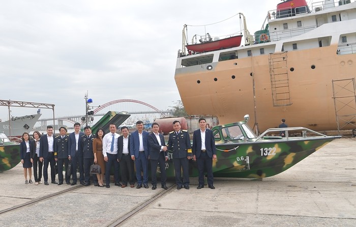 Các đại biểu chụp ảnh kỷ niệm bên chiếc xuồng CQ-01 do Vietcombank tặng bộ đội Trường Sa.