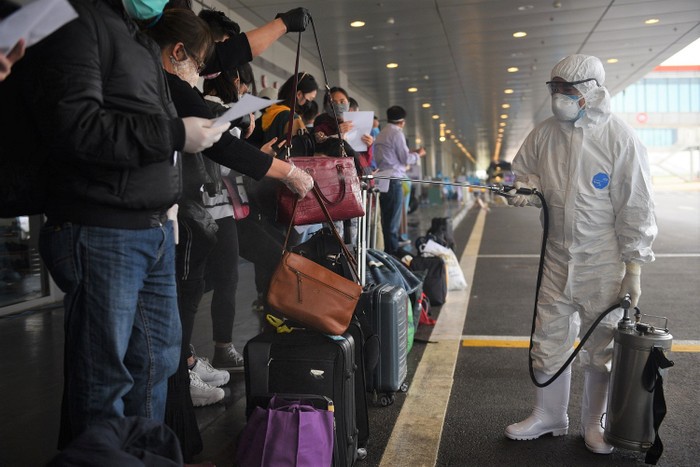Phun xịt khử khuẩn hành lý xách tay của hành khách về từ vùng dịch.