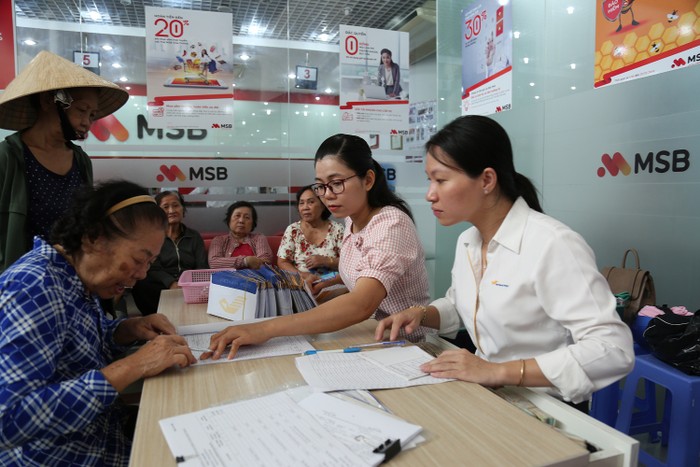 Nhân viên Bưu điện tỉnh Tiền Giang chi trả lương hưu, trợ cấp bảo hiểm xã hội tại điểm chi trả.