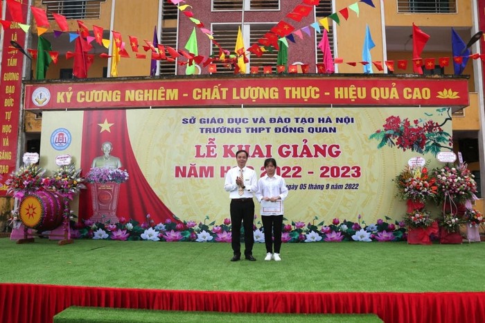 Hiệu trưởng Trường Trung học phổ thông Đồng Quan (huyện Phú Xuyên, Hà Nội) trao giấy khen cho Đinh Thị Thảo Vi vì thành tích đạt được trong kỳ thi tốt nghiệp trung học phổ thông năm 2022. (Ảnh: Nhân vật cung cấp).