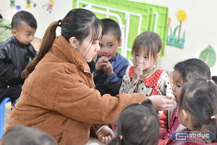 Giáo viên mầm non Lầu Thị Mai cùng các em học sinh ở điểm trường Sà Lủng, Trường Mầm non Pả Vi. (Ảnh: Mai Huệ).