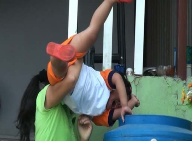 Một bé trai hốt hoảng gào thét khi bị "bảo mẫu" dọa thả vào thùng nước.