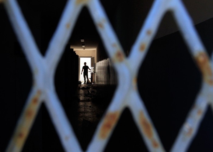3. Đằng sau khung sắt trong một nhà tù ở Abu Salim, Tripoli.