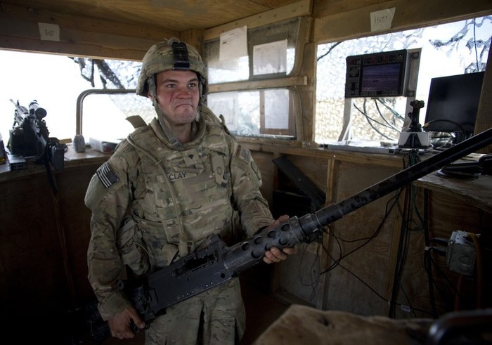 Một binh sỹ Mỹ vừa lau, chùi khẩu súng máy 12,7 mm trong chốt gác của mình.