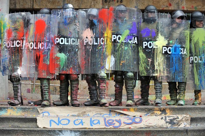 Cảnh sát chống bạo động đứng dàn hàng ngang, hứng chịu những quả bóng nước đầy màu sặc sỡ từ các giáo viên và sinh viên biểu tình tại Bogota, Colombia đang đấu tranh bảo vệ, yêu cầu chính quyền tiếp tục coi trọng sự nghiệp giáo dục công cộng ngày 7/92011.