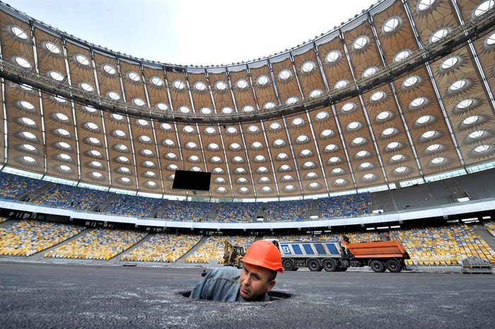 Một công nhân xây dựng chui lên từ một nắp cống tại một công trình xây dựng sân vận động chuẩn bị cho Giaỉ vô địch hiệp hội bóng đá Liên minh châu Âu Euro 2012 ở thủ đô Kiev, Ucraina ngày 8/9/2011.